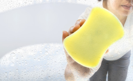 Asian woman cleaning window glass