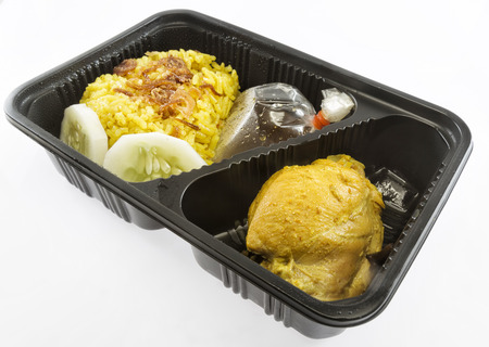 Chicken biryani with yellow rice in packing box on white backgroundの写真素材