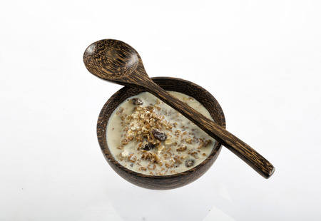 Wooden Bowl of muesli with milk isolated on white backgroundの写真素材