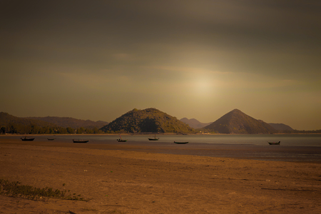 Small fishing boats parked on the beach at sunset.の写真素材