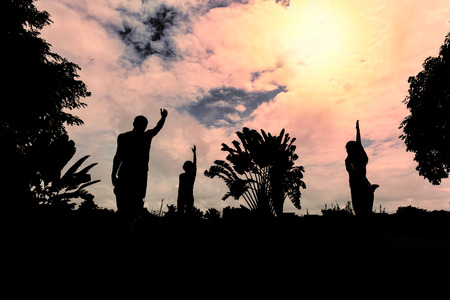 Silhouette men and women yoga exercising training  in the Park.の写真素材