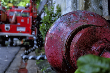 Firefighters truck with flowing worthless old hydrant