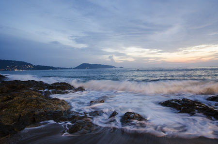 speedy wave on beach with rock sunset time holidayの写真素材