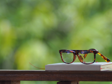 book and note glasses on green back ground work spaceの写真素材