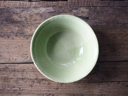 Empty green bowl on wooden background. Top view. Copy space.の写真素材