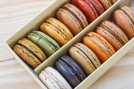traditional french sweet dessert colorful delicious macarons in a rows in a box on wood background...