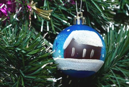 Toy fur-tree sphere with the drawn house and snowの写真素材