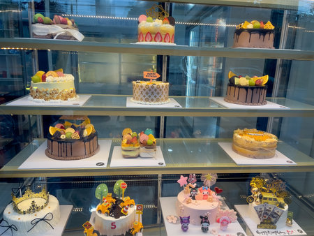 A vibrant display of beautifully decorated cakes and pastries in a bakery showcase. Nha Trang, 26.11.2025, Vietnamのeditorial素材