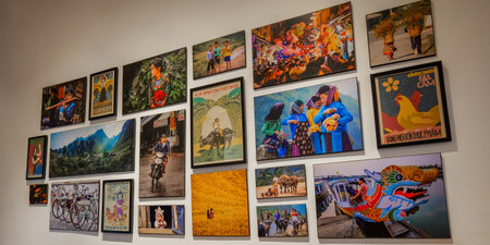 Vibrant wall art display in a Vietnamese cafe, showcasing diverse cultural photographs and vintage posters depicting daily life, landscapes, and traditions. Red Gate Bakery Cafe Nha Trang, 26.11.2025, Vietnamのeditorial素材