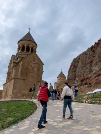Tourists walking toward ancient stone monastery in mountain valley Yerevan 20.04.2023 Armenia.のeditorial素材