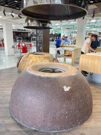 Traditional bakery with tandoor ovens and man preparing dough Yerevan 20.04.2023 Armenia.のeditorial素材