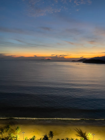 Tropical seascape at dusk with orange horizon and gentle waves in Nha Trang, 07.11.2025, Vietnam.のeditorial素材