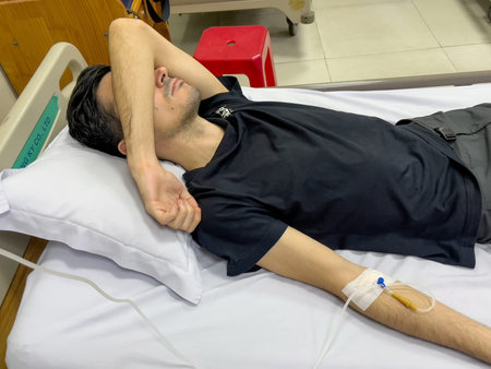 Patient with IV line resting in hospital bed, Nha Trang, October 18, 2025, Vietnamのeditorial素材