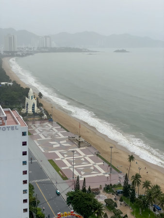 Coastal cityscape with beach, sea, and distant mountains under cloudy sky Nha Trang 06.11.2025, Vietnam.のeditorial素材