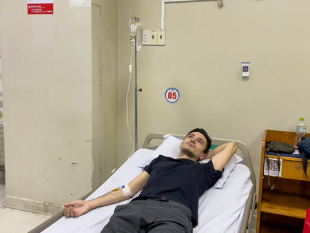 Patient lying in hospital bed with IV drip attached, Nha Trang, October 18, 2025, Vietnamのeditorial素材