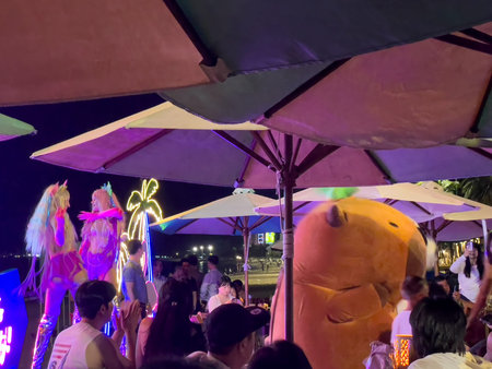 Night party at beach bar with neon lights and costumed performers. Nha Trang, October 10, 2025, Vietnam.のeditorial素材