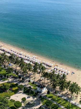 Bright sandy beach with palm trees and white umbrellas by turquoise sea in Nha Trang, October 17, 2025, Vietnamの写真素材