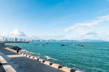 Coastal City Skyline of Nha Trang Vietnam with Traditional Fishing Boats on Turquoise Sea, Bright Sunny Daylight, Wide Angle Landscape with Copy Space Nha Trang 20.12.2025 Vietnamのeditorial素材