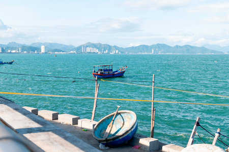 Traditional Blue Fishing Boat and Basket Boat in Vietnam Coastal Cityscape. Scenic Mountains and Turquoise Water. High-res Travel Stock Photography. Nha Trang 20.12.2025 Vietnamの写真素材