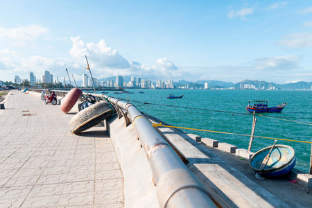 Traditional Vietnamese Basket Boats on Nha Trang Coastal Promenade with Modern City Skyline, Cinematic Sunlight and Deep Blue Ocean Nha Trang 20.12.2025 Vietnamのeditorial素材