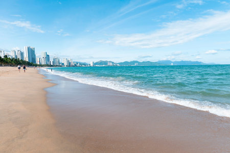 Cinematic Panoramic Tropical City Beach with Skyscrapers and Turquoise Ocean Waves; Wide-Angle Coastal Landscape of Nha Trang Vietnam for Travel Ads. Nha Trang 20.12.2025 Vietnamのeditorial素材