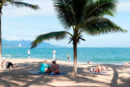 Relaxing Summer Vacation on Tropical Beach with People Sunbathing under Palm Trees, Ocean View and Clear Blue Sky for Travel and Tourism Marketing. Nha Trang 20.12.2025 Vietnamのeditorial素材