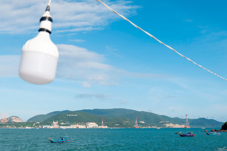 Scenic Coastal View of Nha Trang Vietnam with Vinpearl Island Resort and Fishing Boats featuring Selective Focus on Foreground LED Bulb and Blue Sky Nha Trang 20.12.2025 Vietnamのeditorial素材