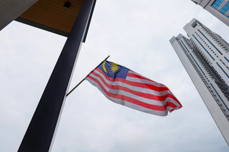 Malaysian Flag Jalur Gemilang Waving Against Skyscrapers in Kuala Lumpur Urban Cityscape. Kuala Lumpur 29.01.2026 Malaysiaのeditorial素材
