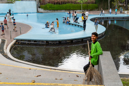 Smiling Male Park Worker with Broom at KLCC Park Wading Pool in Kuala Lumpur 29.01.2026 Malaysia