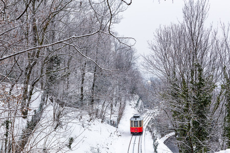 The historical Sassi â Superga ( Turin-Italy) rack tramway in winter time.The rack tramway is drawn by a locomotive carriage with a maximum tow of two wagons and capacity of 210 passengers.の写真素材