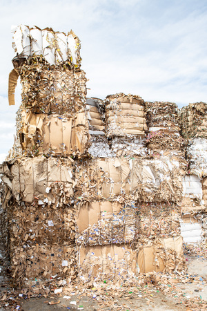 Pile of pressed waste paper bales in the yard.  Waste paper recycling.の写真素材