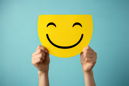 Smiley face on a yellow sheet of paper held by a womanの素材