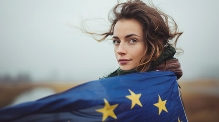 Beautiful young woman with the flag of the European Union in her handsの素材