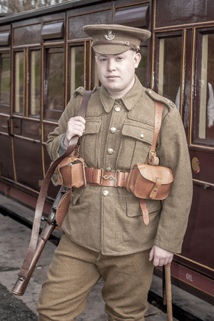 Tanfield, UK, March 13, 201: Reenactor WW1 weekend. A young british soldier about to board a steam train at Andrew's House station, Tanfield Railway, the oldest railway in the world.のeditorial素材
