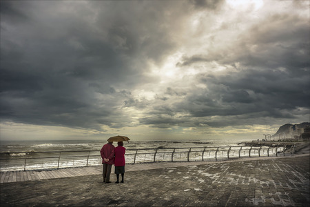 Old couple staring at the horizon at seaのeditorial素材