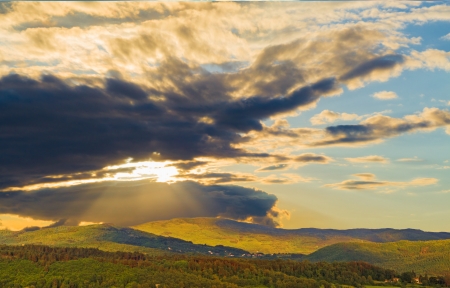 It is nearing time of the sunset and the sun rays of early summer, which filter through the clouds, light up the hills of Tuscany (Italy).の写真素材