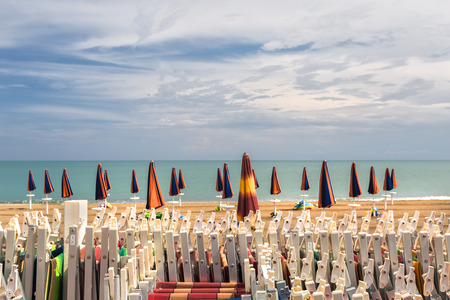 At the beginning and at the end of the bathing season the umbrellas are closed waiting for a few days of warm sunshine.の写真素材