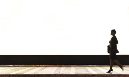 A backlit poster advertising in a terminal station. The slow time in the photo shoot has allowed us to make the ethereal person.の写真素材