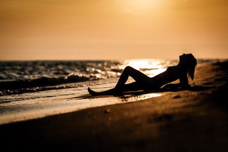 Girl on the beach at sunsetの写真素材