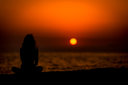 Girl in sunset meditationの写真素材