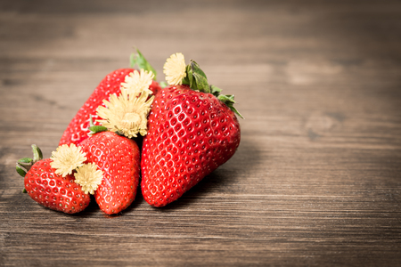 Strawberries, typical summer fruit. A composition with few fruits placed on an old table. A good and healthy type of fruit that contains few sugars.の写真素材
