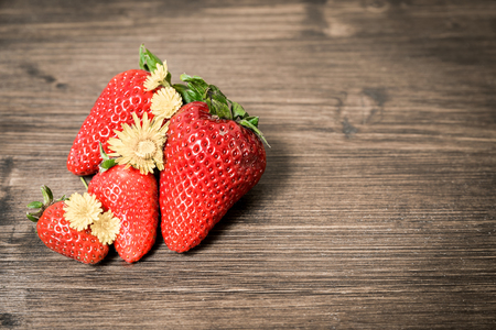 Strawberries, typical summer fruit. A composition with few fruits placed on an old table. A good and healthy type of fruit that contains few sugars.の写真素材