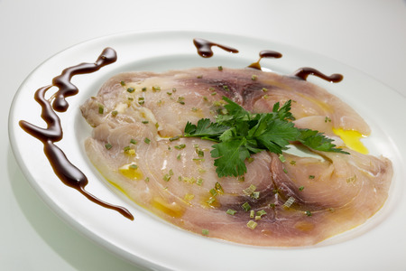 A delicious carpaccio of fresh Mediterranean swordfish, seasoned with extra virgin olive oil, chives, parsley and a few drops of orange juiceの写真素材