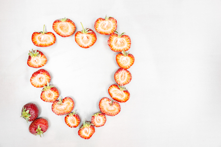 A half-cut strawberry almost seems to form a heart. And many strawberries cut in half form a big heart. Strawberry is a typical summer fruit that is the season of love. A kind of good and healthy fruit that contains few sugars.の写真素材
