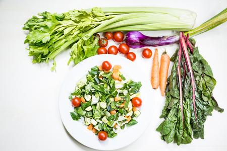 A mix of fresh vegetables on a table ready to be cooked to tasteの写真素材