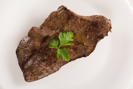 High angle view of a veal liver steack on a white plateの写真素材