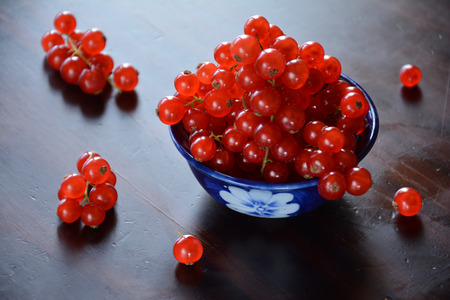 Against the light view of redcurrant berries in a ceramics bowlの写真素材