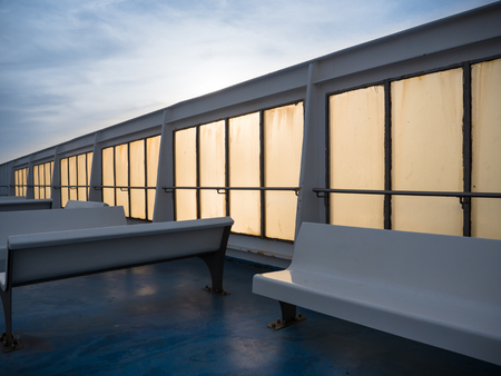 Benches on an empty  ferry deck at sunsetの写真素材