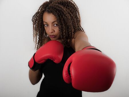 Horizontal portrait of an Afro American woman wearing red boxing glovesの写真素材