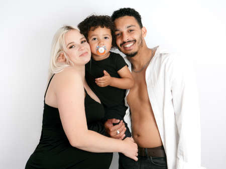 Portrait of a stylish and happy multi-ethnic family expecting a babyの写真素材